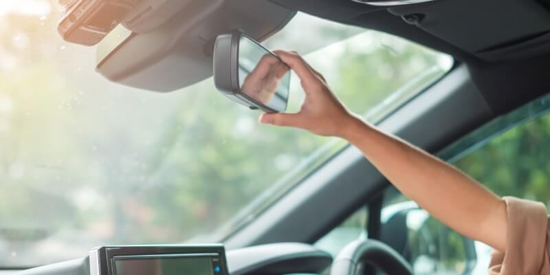 Hand reaching to move rearview mirror