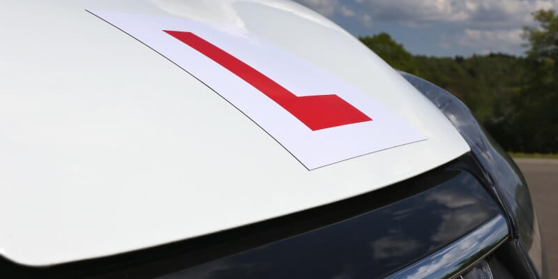 Learner sign placed on bonnet of a white car